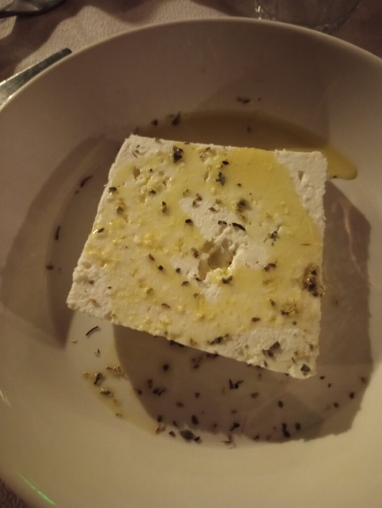 A block of feta with herbs and a drizzle of olive oil